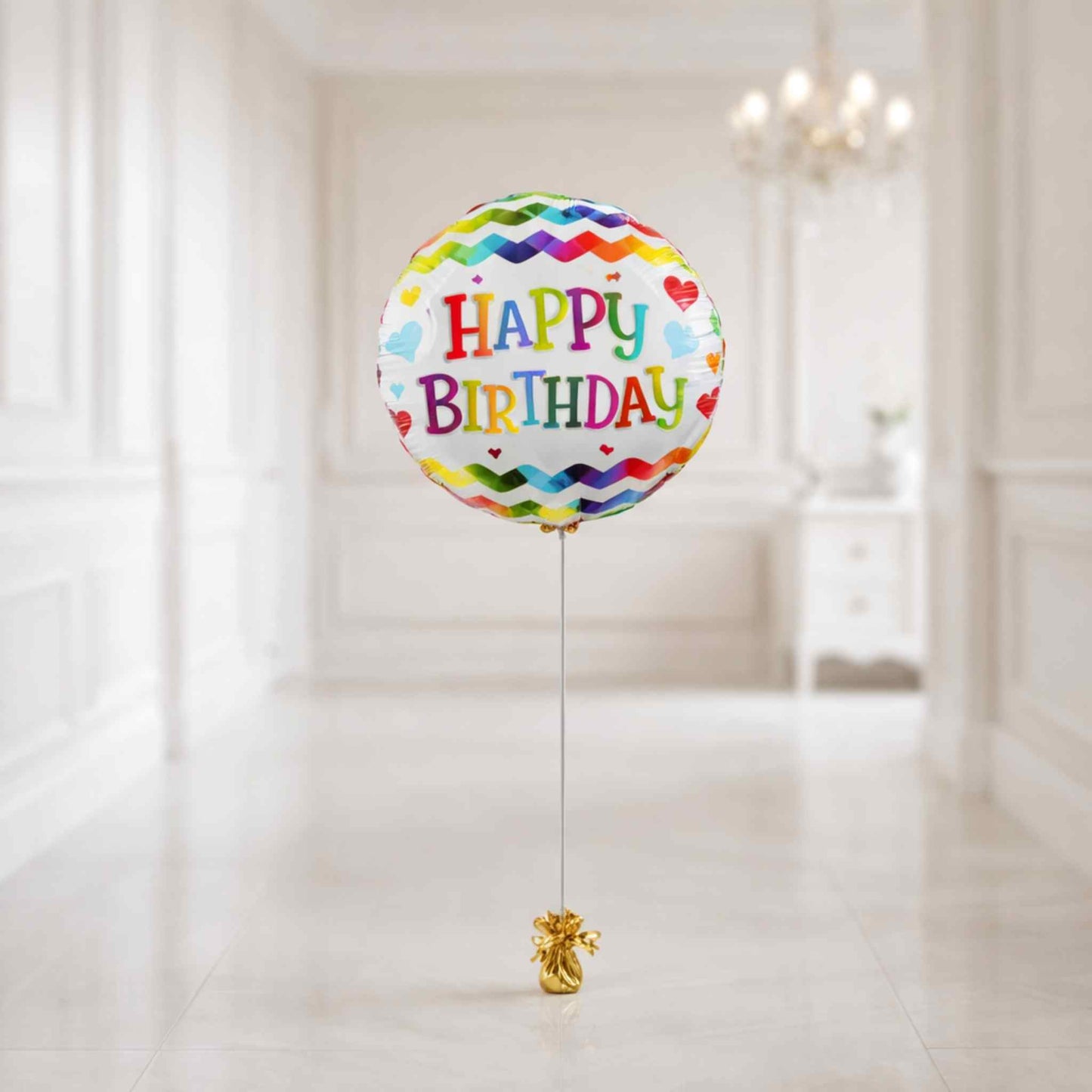 Colorful 'Happy Birthday' balloon with a gold ribbon on a white background