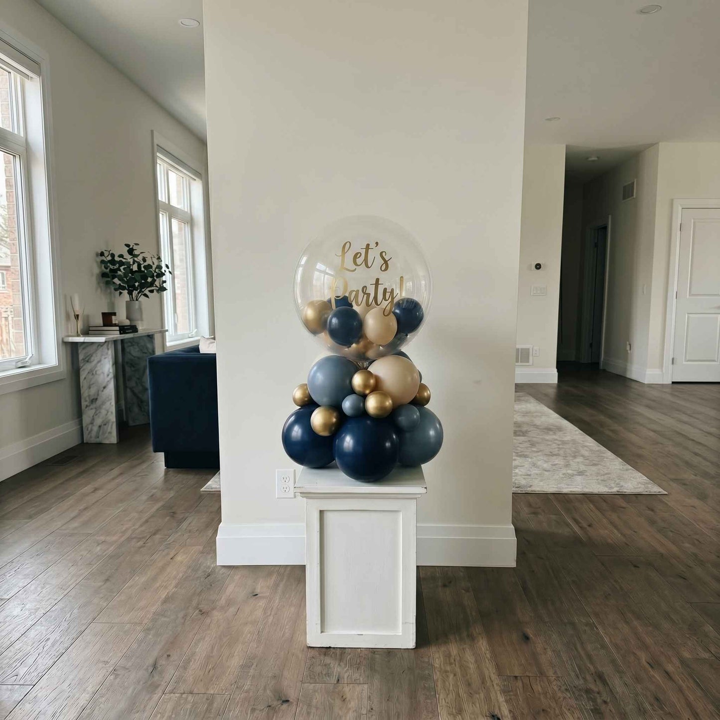 lets party bubble stack tower on pillar. Gold and dark blue staged in large apartment