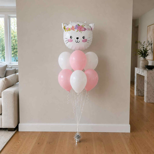 Cat-shaped balloon with pink and white balloons in a living room setting