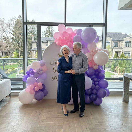 happy birthday balloon backdrop pink and purple colour. apartment setup woman and man standing infront