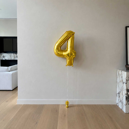 a large gold number 4 balloon in a modern living room.