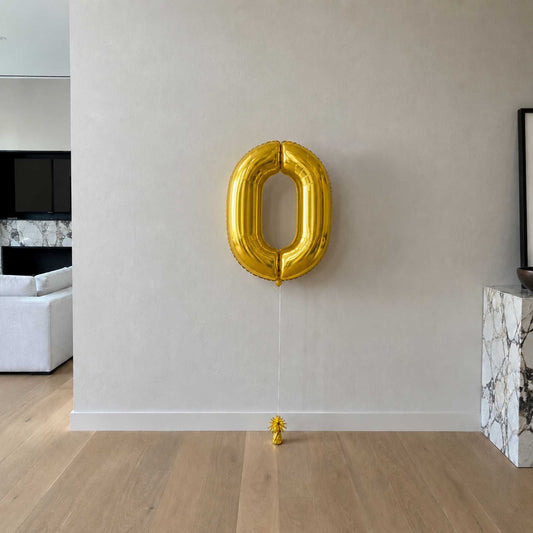 large number foil 0 against a white wall with gold weight