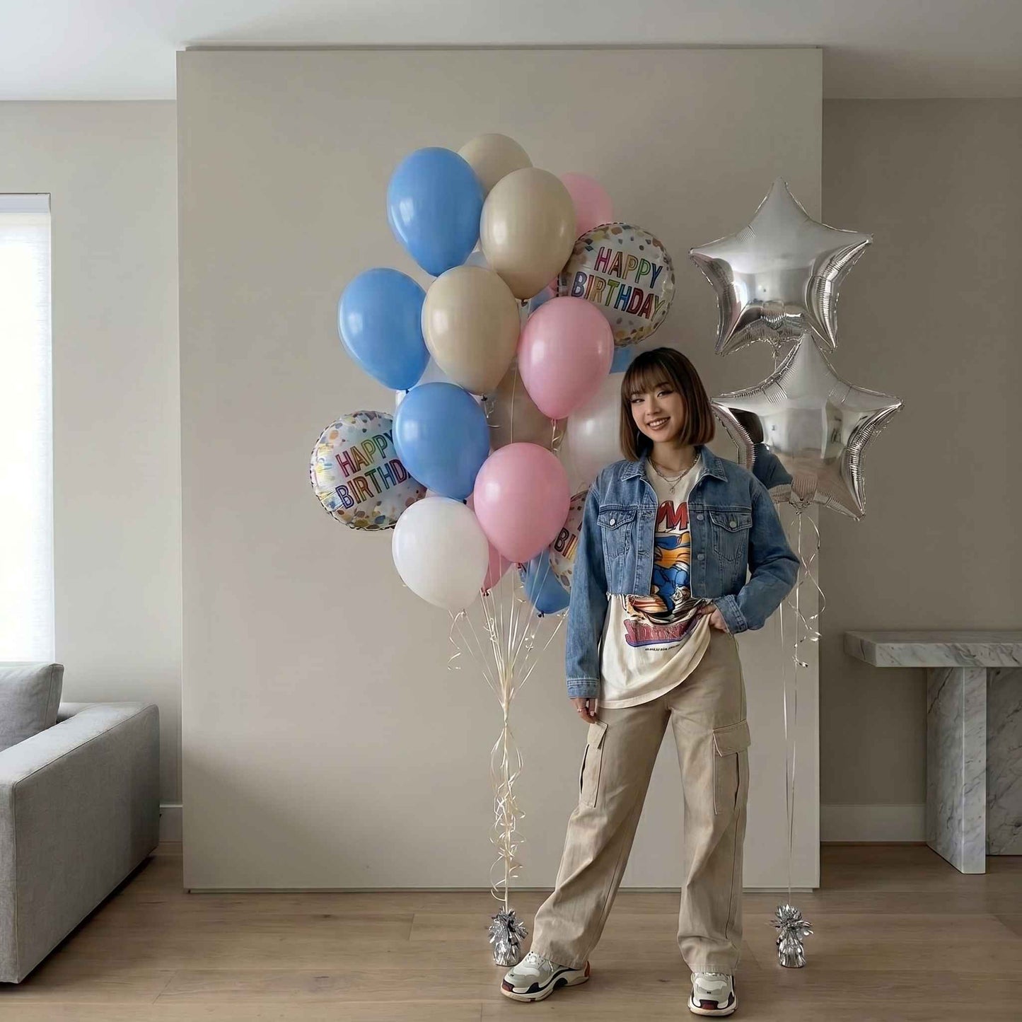 Person holding a bouquet of balloons with 'Happy Birthday' signs in a room.