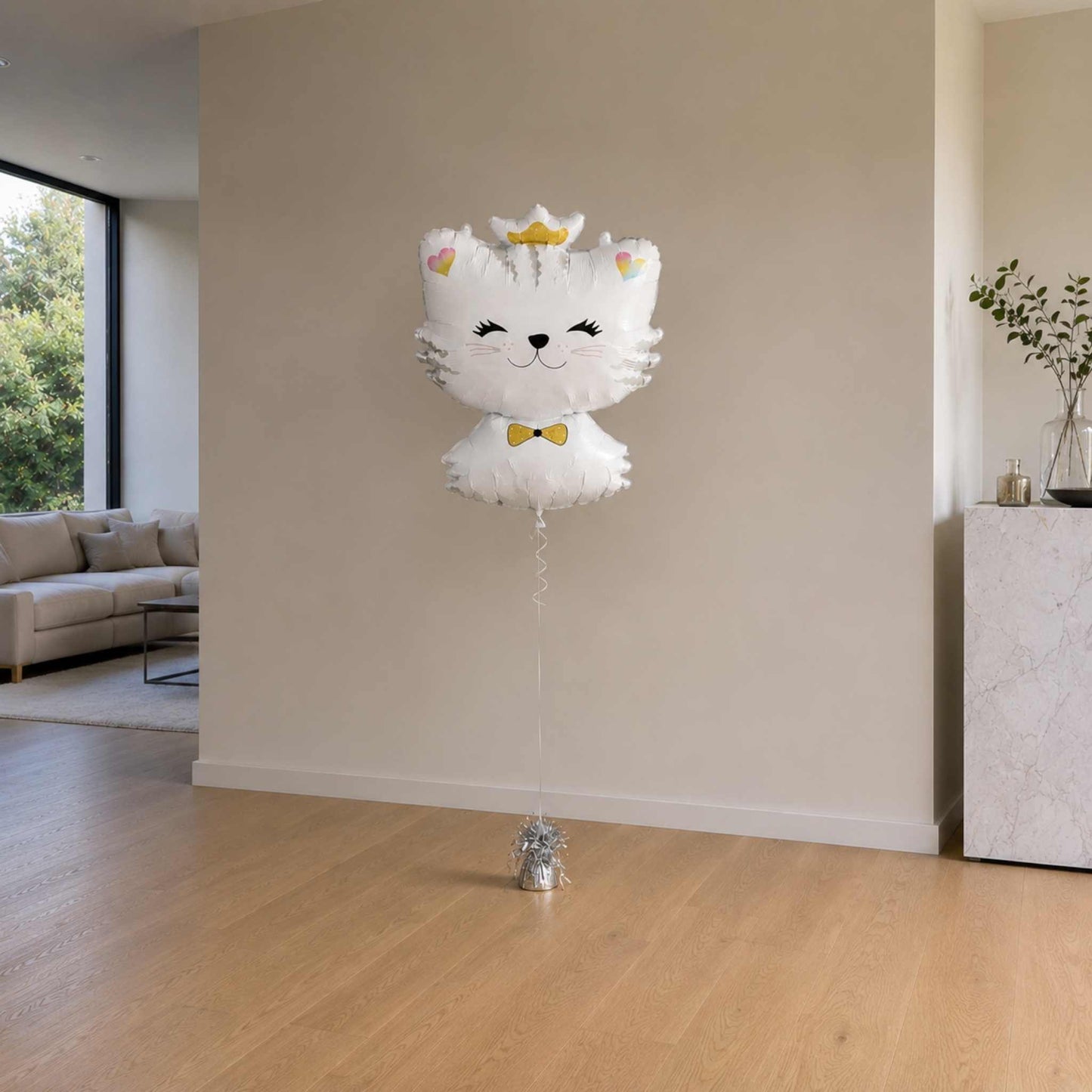 Cat-shaped balloon with a bow tie in a living room setting