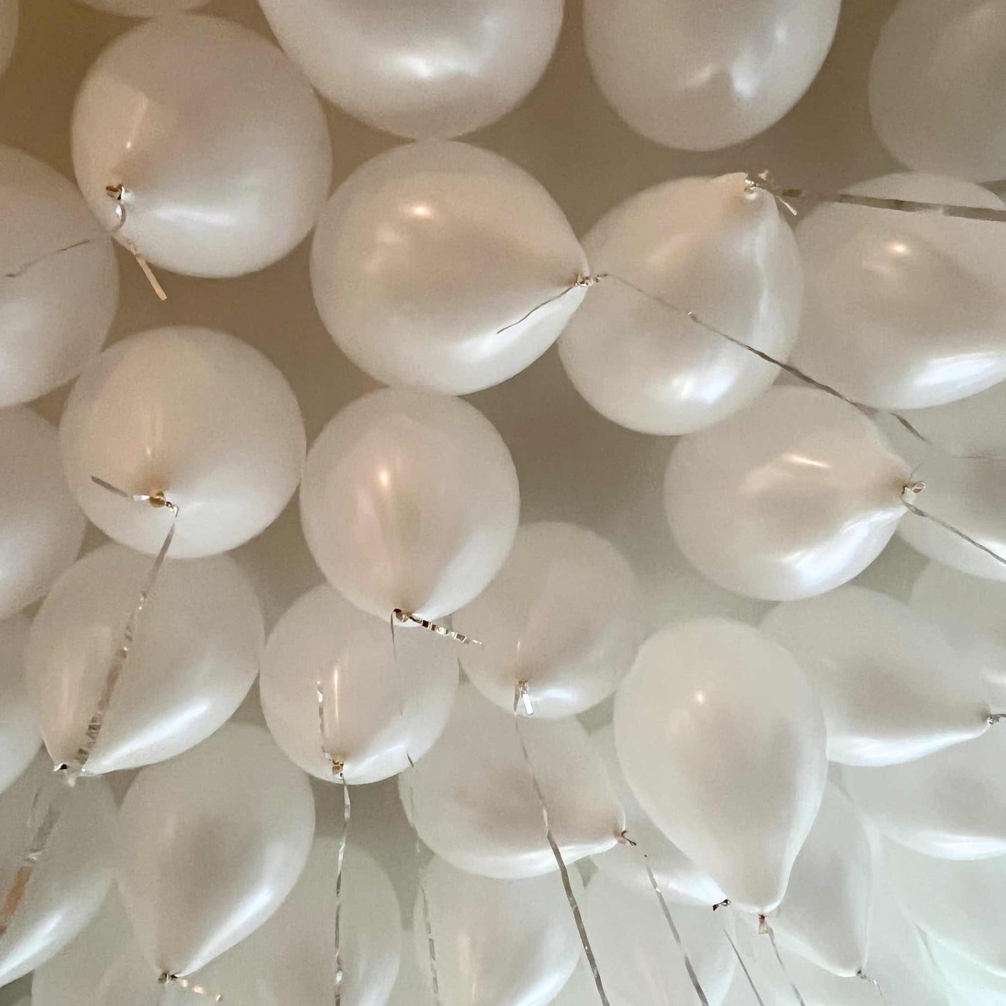 Close-up of white balloons against a neutral background