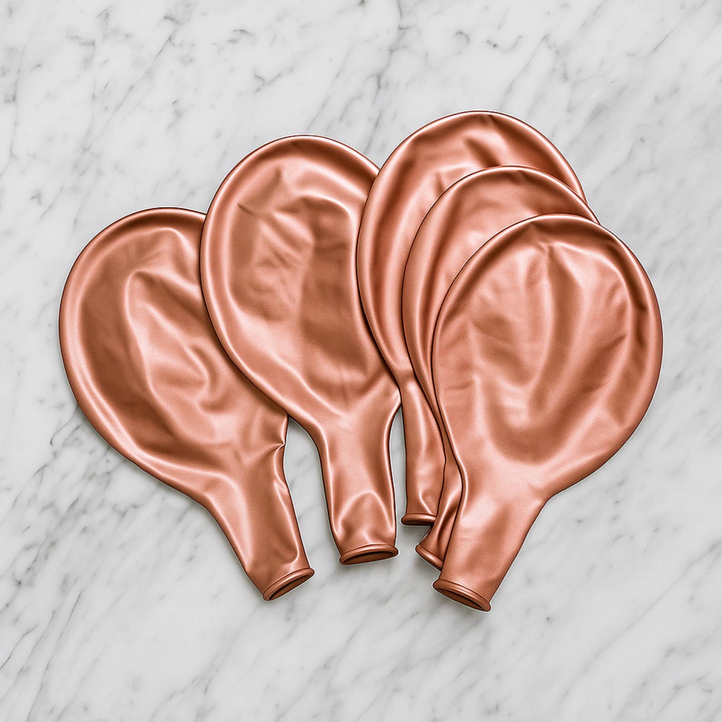 Set of rose gold balloons on a marble surface