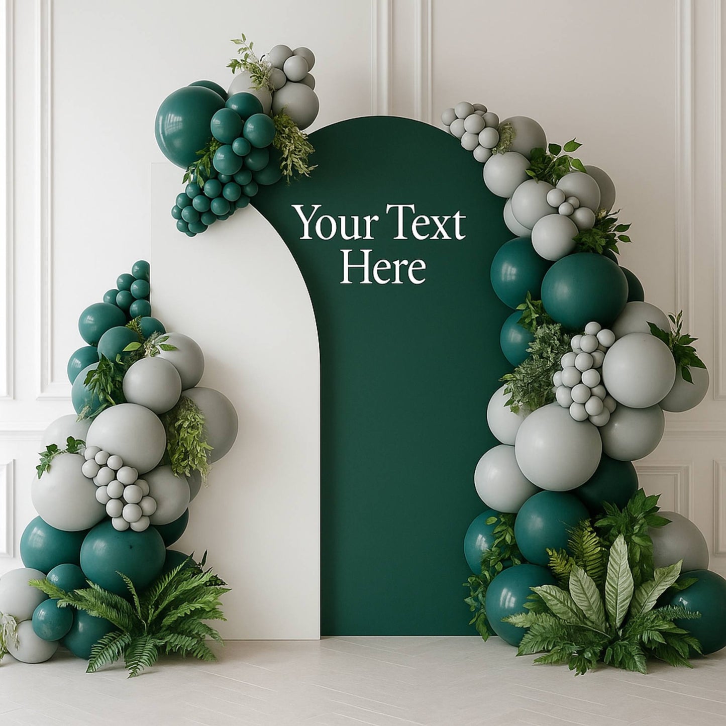 Decorative arch made of balloons and greenery with a text placeholder on a white wall.
