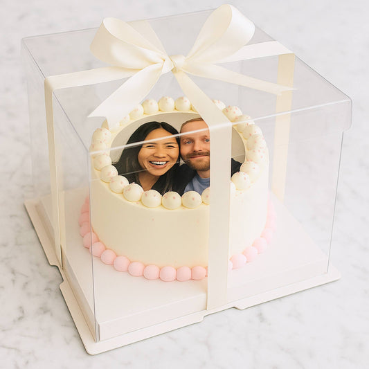 Decorative cake with a clear box featuring a photo of a couple on a marble surface