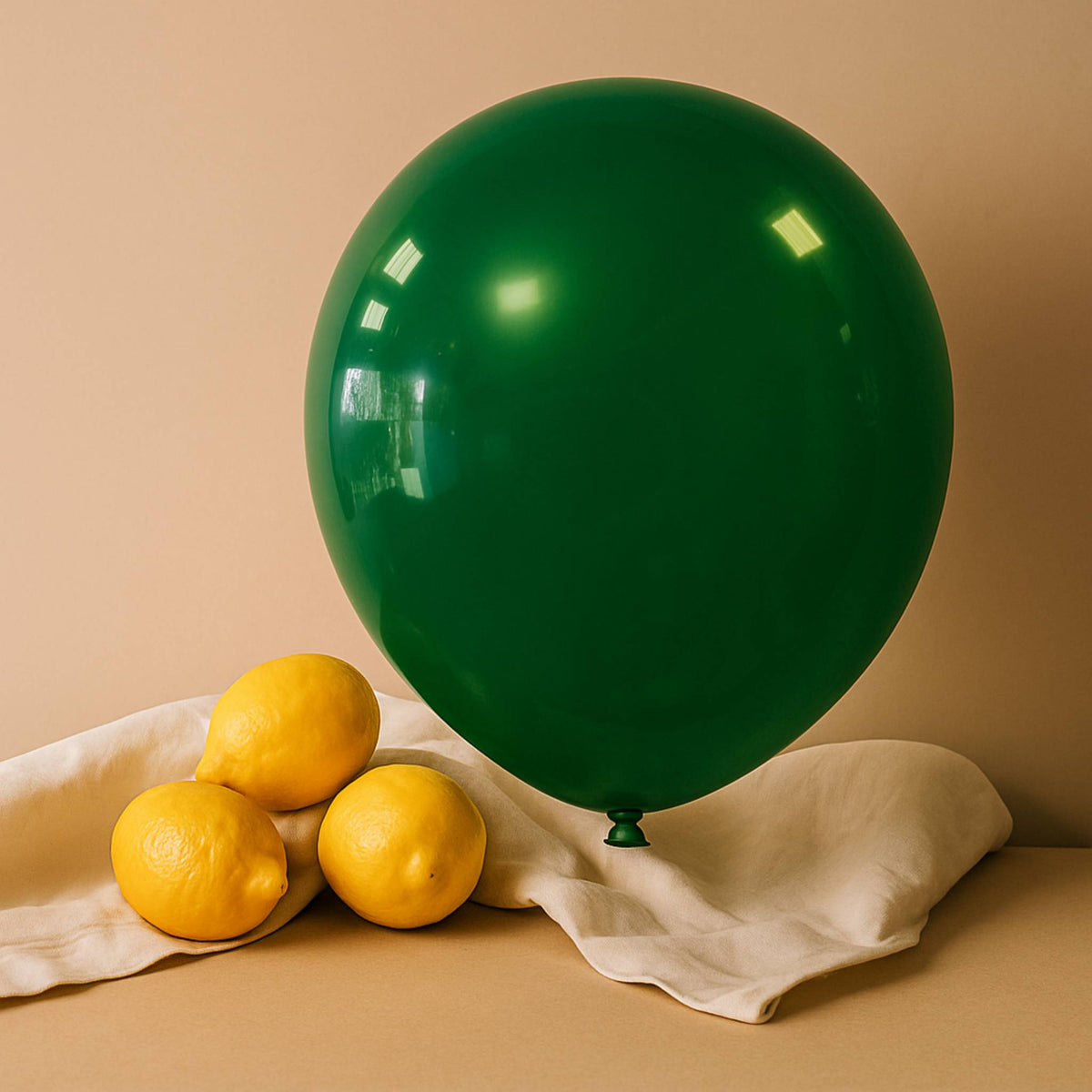 Green balloon and lemons on a beige surface with a beige background