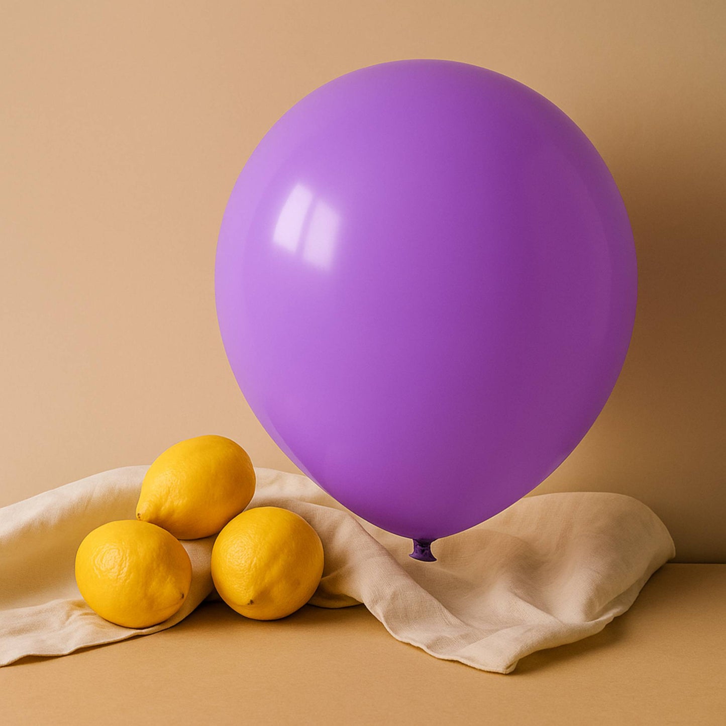 Purple 11 inch helium balloon and lemons on a beige background