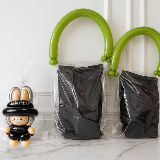 Two black plastic bags with green handles on a marble surface, next to a labubu balloon.
