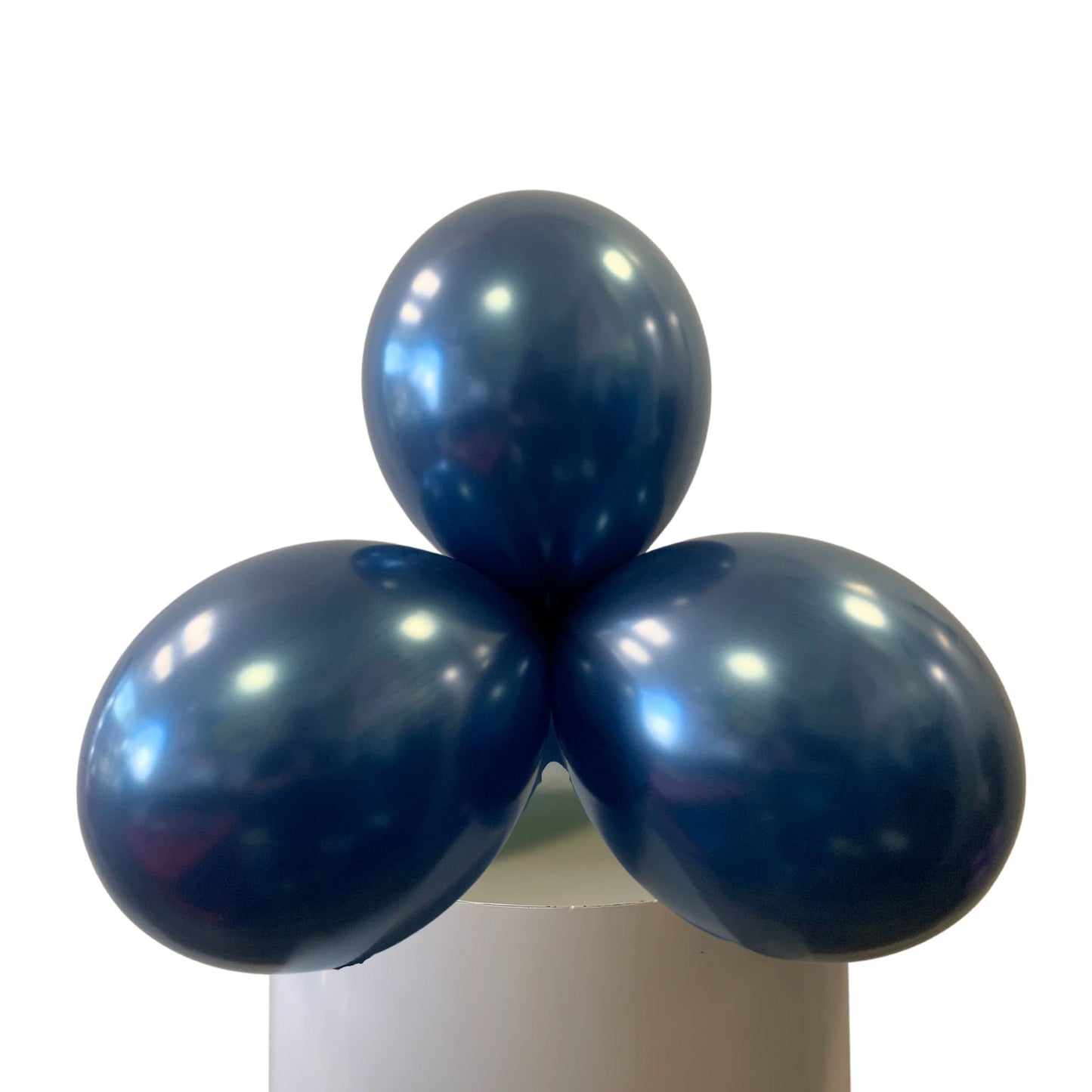Three blue balloons on a white stand against a white background