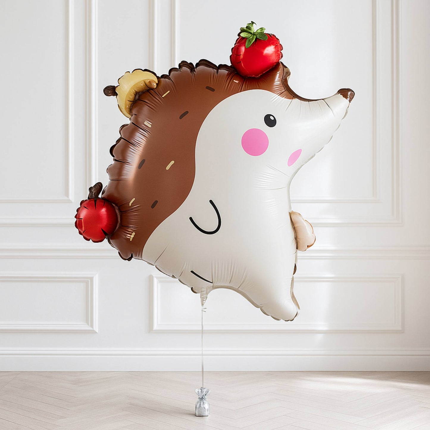 Hedgehog-shaped balloon with apples and a strawberry on a white background