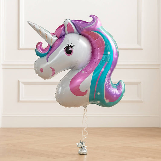 Unicorn-shaped balloon with colorful design on a wooden floor.