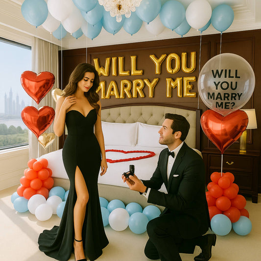 Man proposing to a woman in a black dress with balloons and 'Will You Marry Me?' signs.