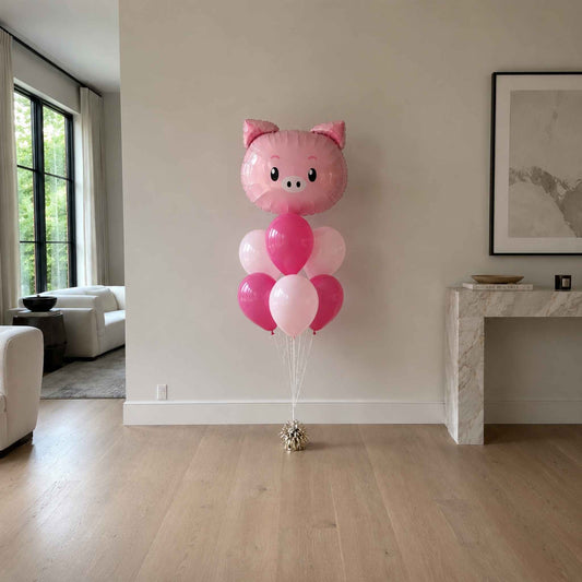 Pink pig-shaped balloon bouquet in a living room setting