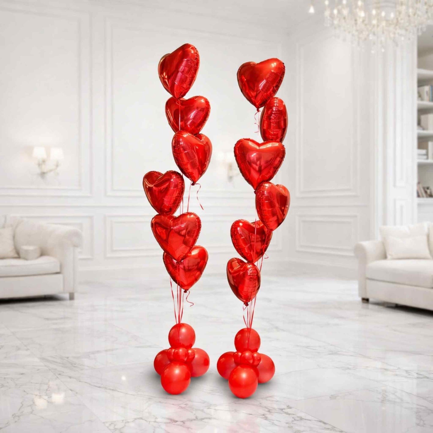 Red heart-shaped balloons arranged in a decorative display in a white room.