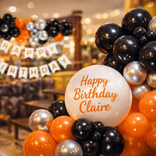 Balloon arch with 'Happy Birthday Claire' text in a festive setting.