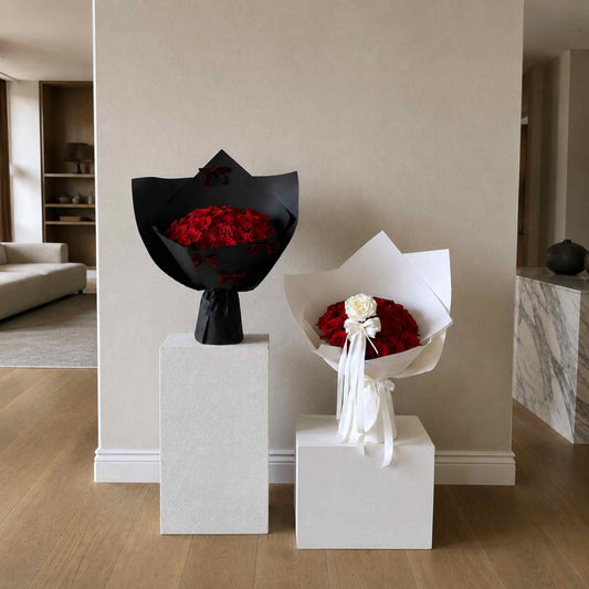 Two bouquets of flowers on white pedestals in a modern interior setting.