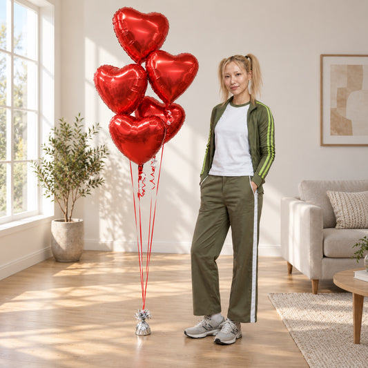five red foil heart bouquet woman side pose house with wood floors