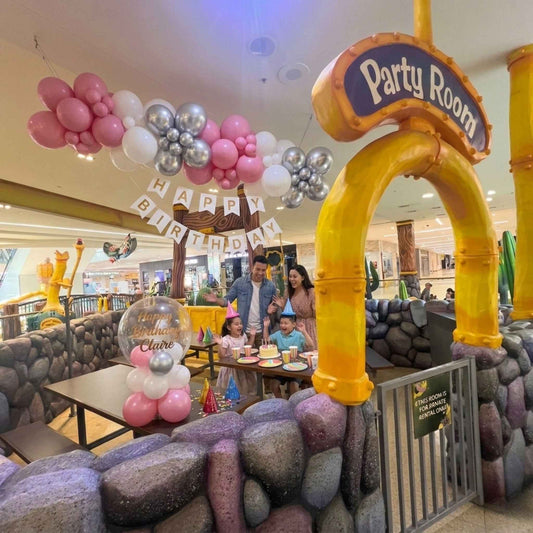 Children's birthday party in a themed room with balloons and decorations.