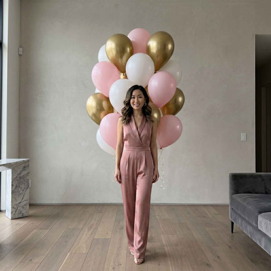 pink, white, and chrome gold balloons in an apartment with woman standing in front 