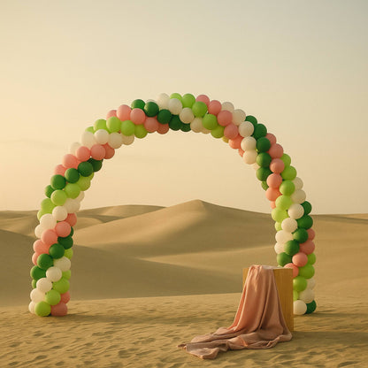 Balloon arch in a desert setting with sand dunes in the background