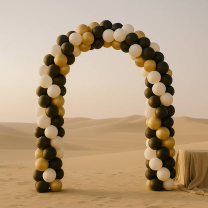 Balloon arch in a desert setting with a beige sky.