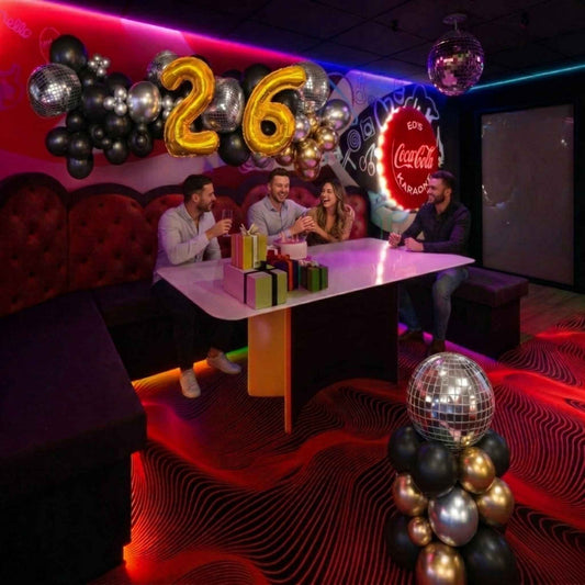 People celebrating a 26th birthday with decorations and Coca-Cola branding in a themed room.