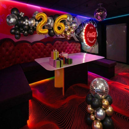 Decorated room with balloons, gifts, and a Coca-Cola sign in a party or celebration setting.