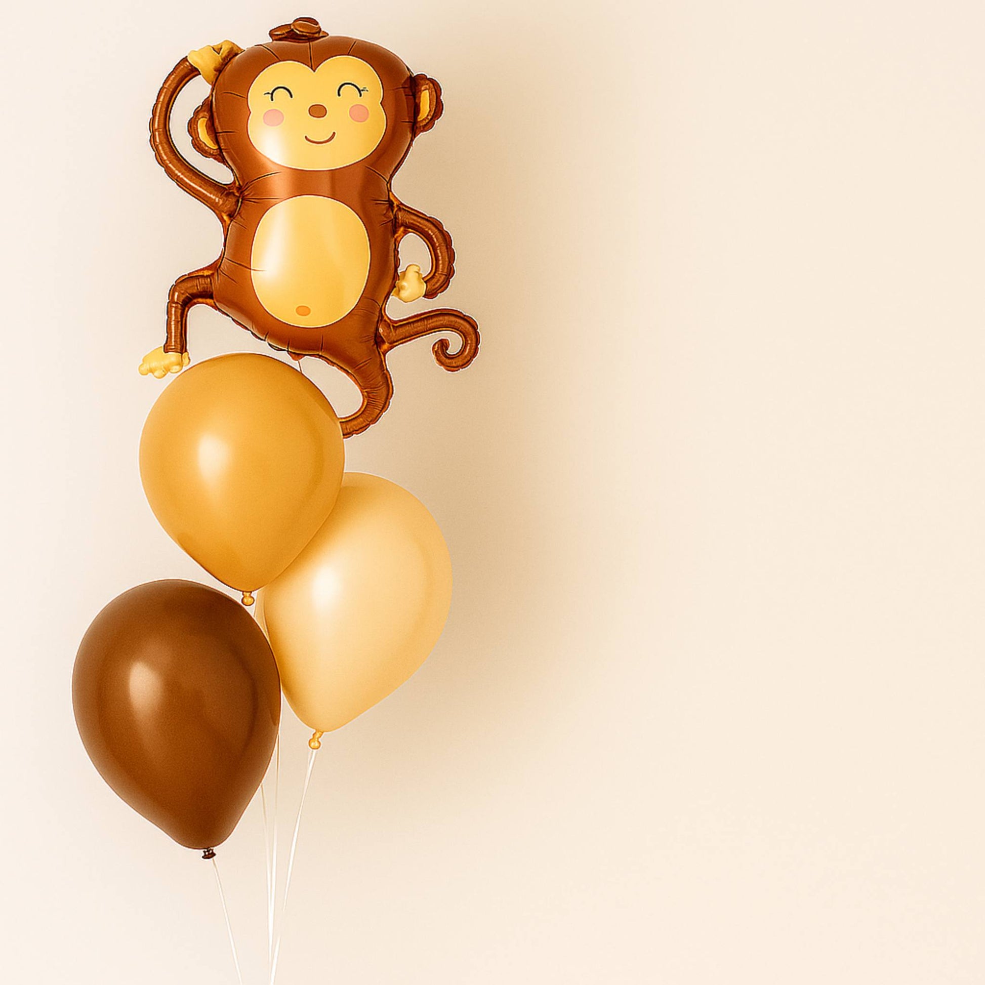 Monkey-shaped balloon with three color-matched balloons on a beige background