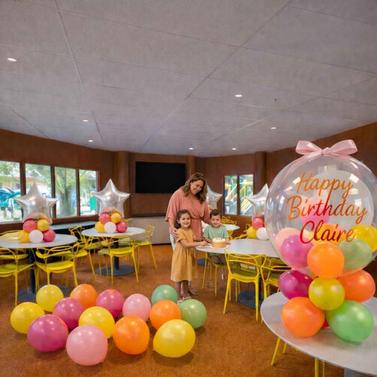 Children's birthday party in a room with colorful balloons and decorations.