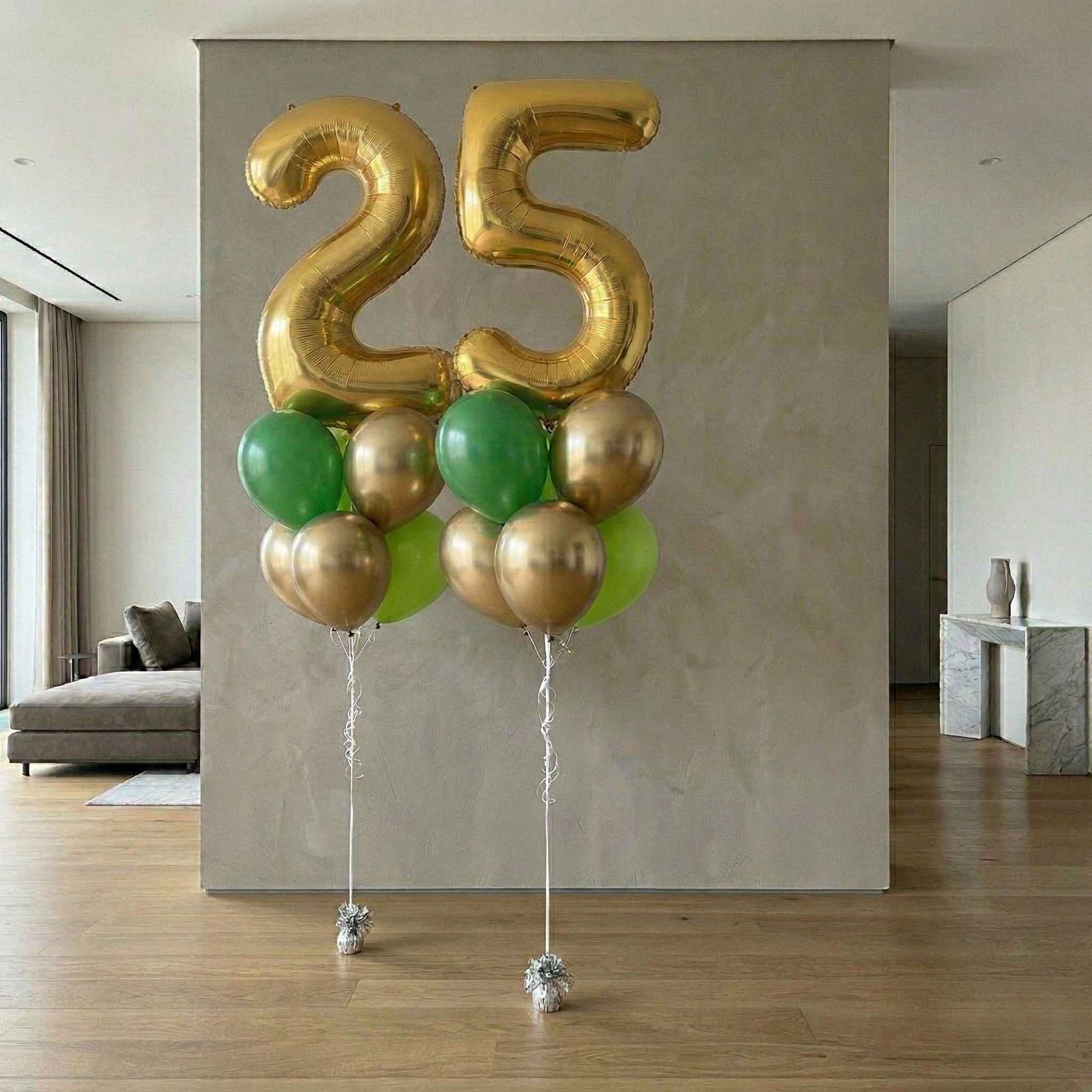 Gold and green balloons shaped like the number 25 in a modern living room.