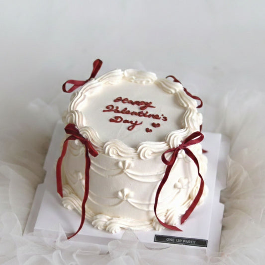 White cake with red text and ribbons on a white background