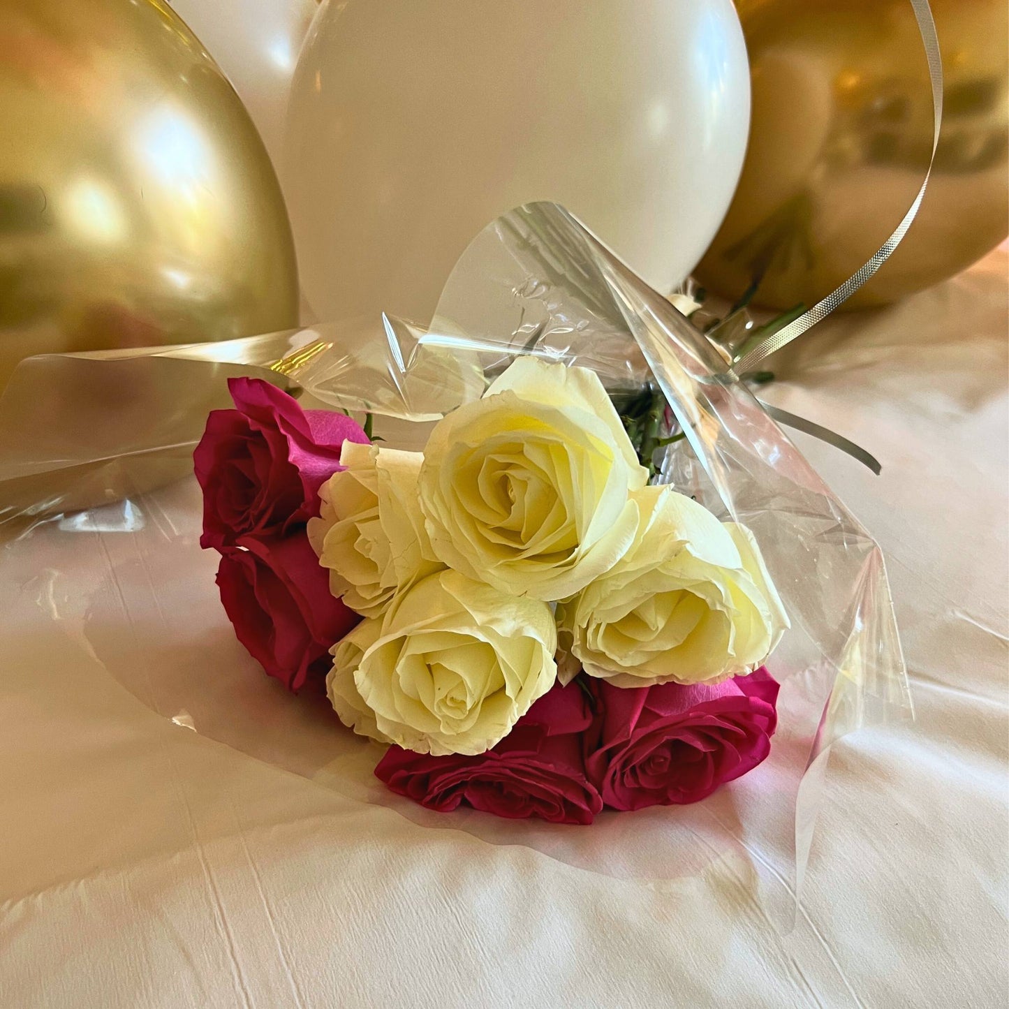 Pink and White Roses on a Bed with balloons