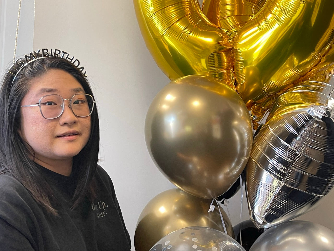 its my birthday headband in silver sitting beside a large balloon bouquet
