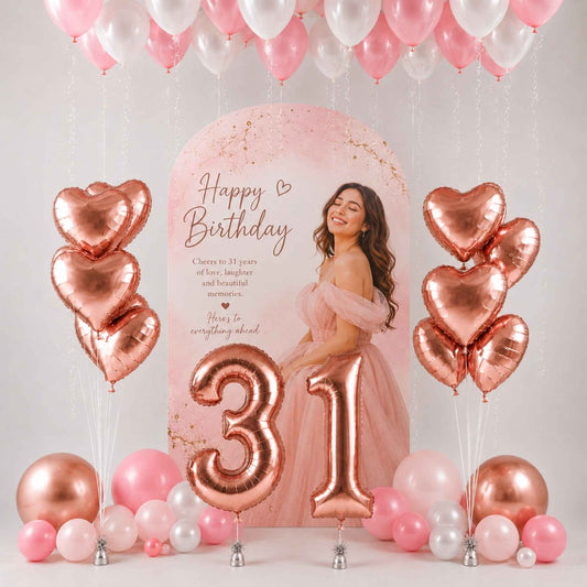 A pink and rose gold 31st birthday party decoration kit featuring a large arch backdrop with a 'Happy Birthday' message, metallic number 31 balloons, heart-shaped balloons, and clusters of pink, white, and rose gold balloons.