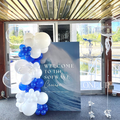 Decorative balloon arch with 'Welcome to the Sofwave Cruise' sign in a boat interior.