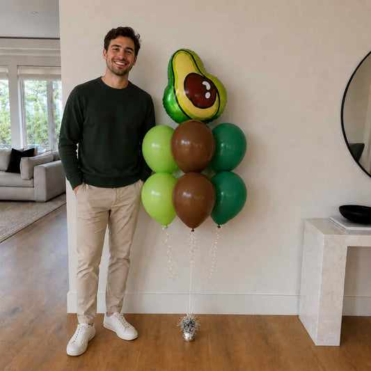 Man holding avocado-shaped balloon in a living room