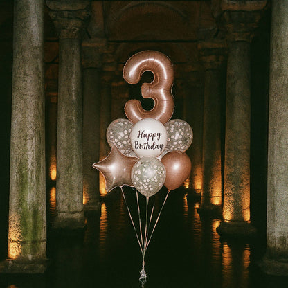 Balloon bouquet with number '3' and 'Happy Birthday' text in a stone archway setting