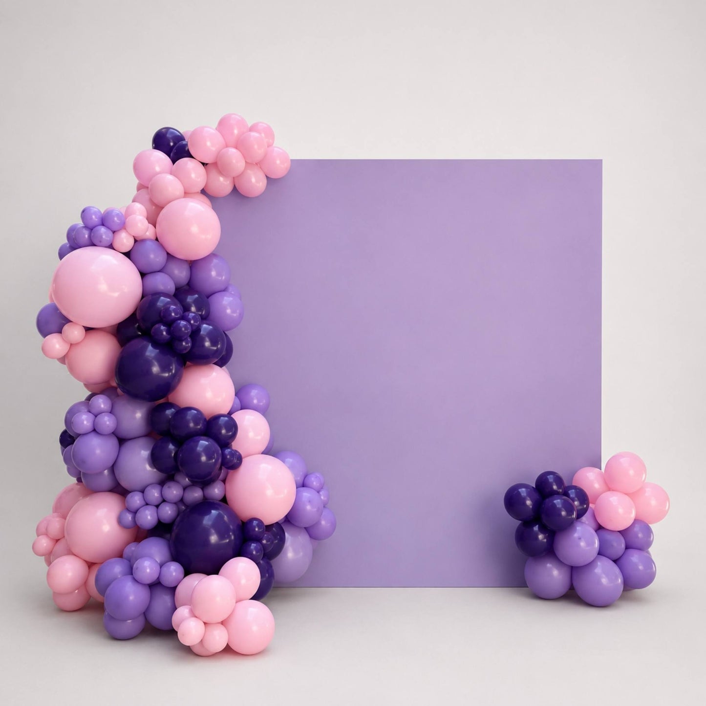 A decorative balloon garland arrangement in pastel pink, lavender, and deep purple, styled around a large lavender rectangular backdrop on a light gray studio background.