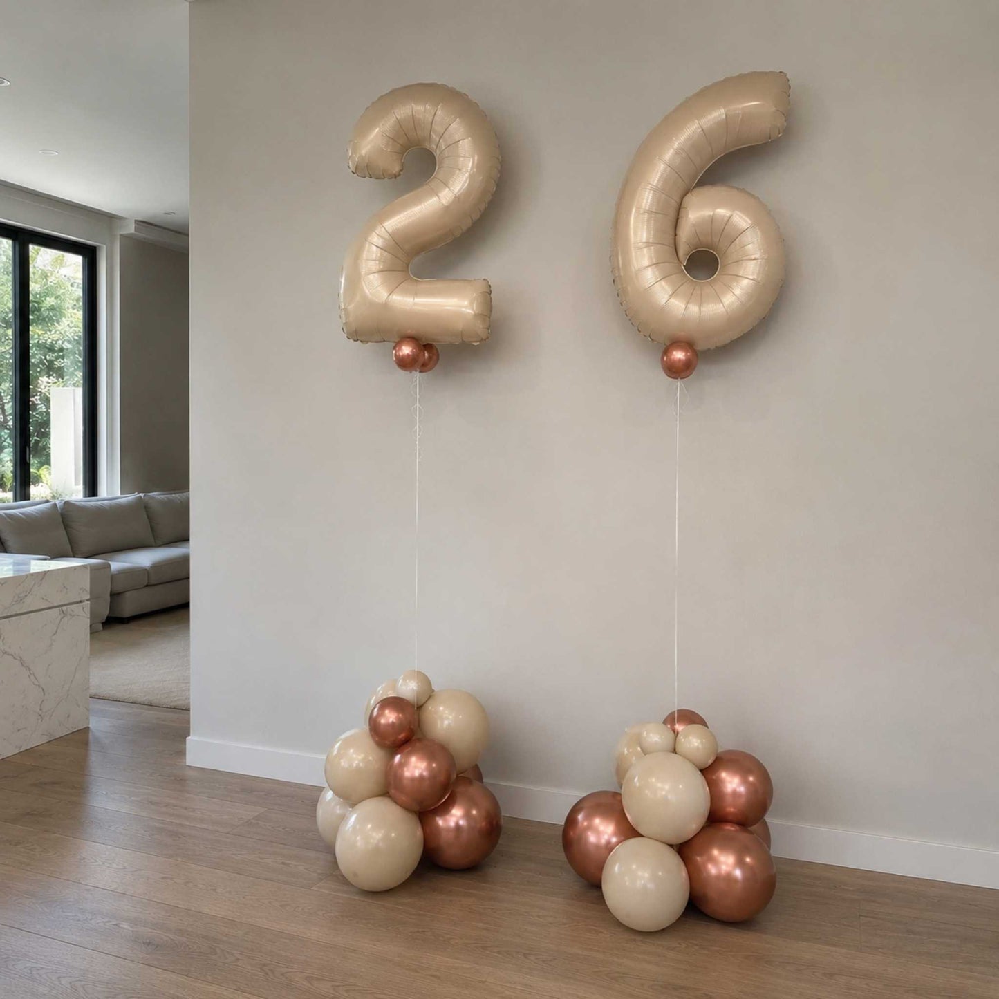 Gold number balloons '26' in a living room setting with decorative balloons on the floor.