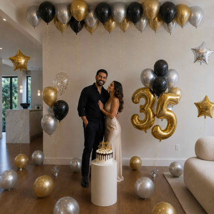 Couple celebrating a 35th birthday with balloons and cake in a decorated room.