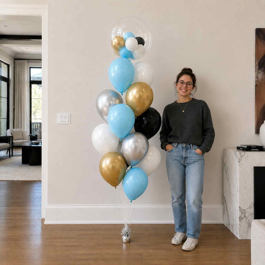 Woman standing next to a large arrangement of colorful balloons in a living room.