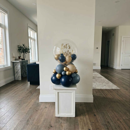 lets party bubble stack tower on pillar. Gold and dark blue staged in large apartment 