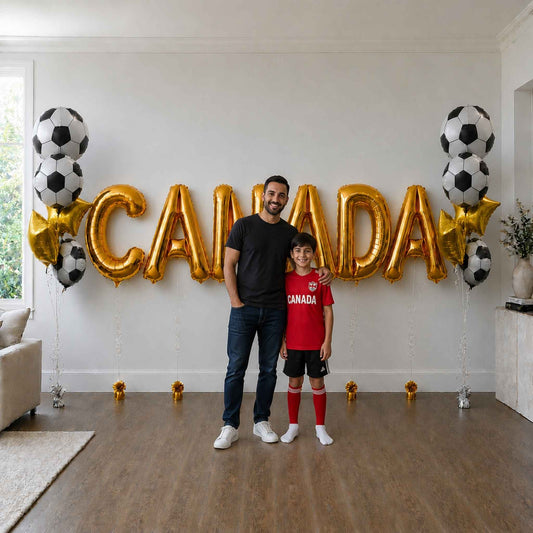 Man and child standing in a room with 'CANADA' balloons and soccer ball decorations.