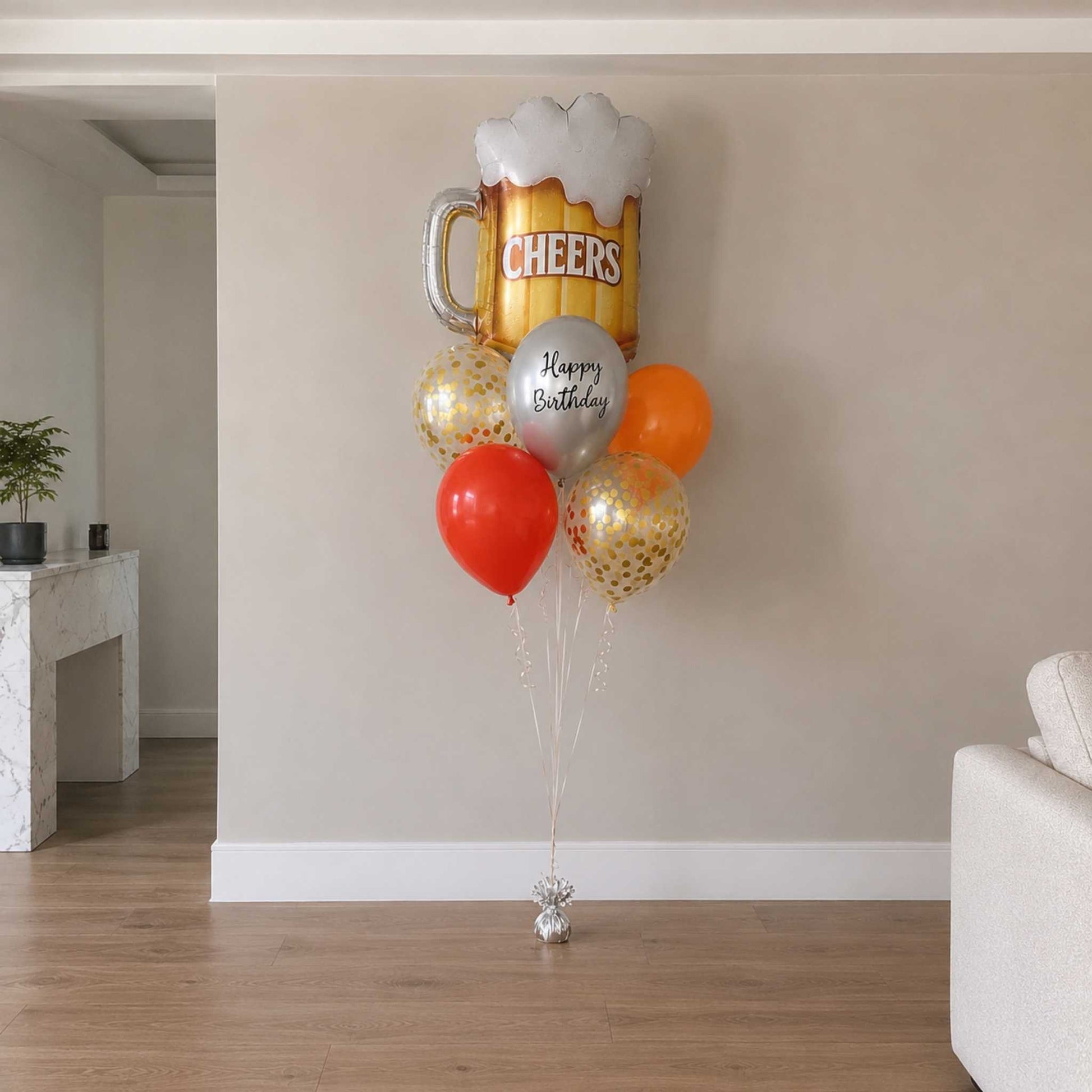 Balloon arrangement with a beer mug and balloons in a living room setting.