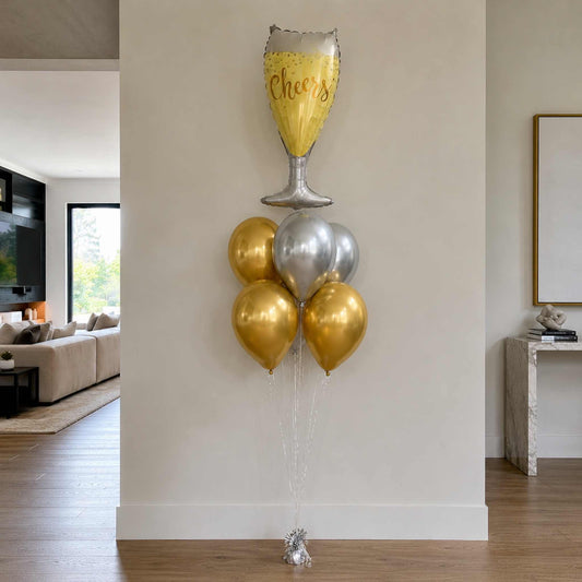 Decorative balloon bouquet with a 'Cheers' glass balloon in a living room setting.
