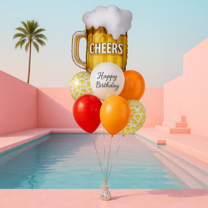 Balloons with a 'Cheers' beer mug and 'Happy Birthday' text in a futuristic setting with a pool and palm tree.