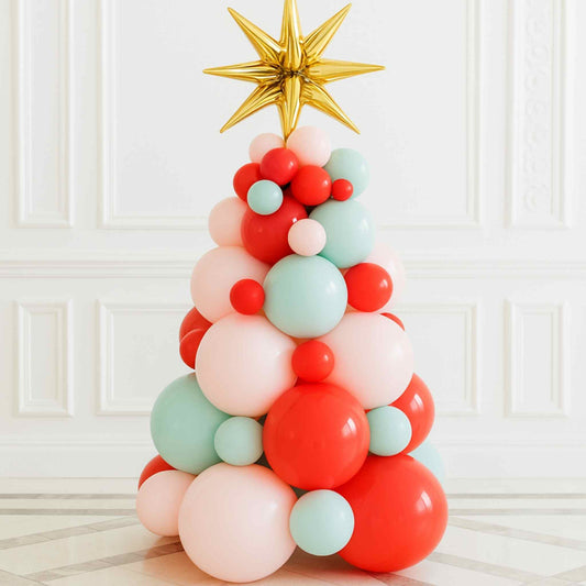 a red pastel green pastel pink christmas balloon tree gift standing on the floor